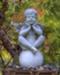 A whimsical boy angel relaxes in a bronze urn with a Black Pine accent.